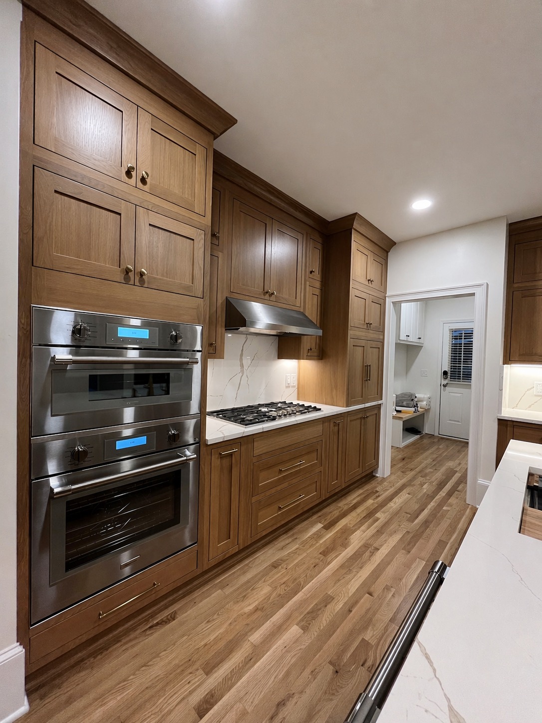 Completed kitchen with custom wood cabinetry and double oven